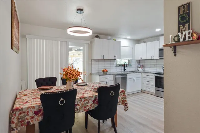 a kitchen with kitchen island granite countertop a sink cabinets and wooden floor