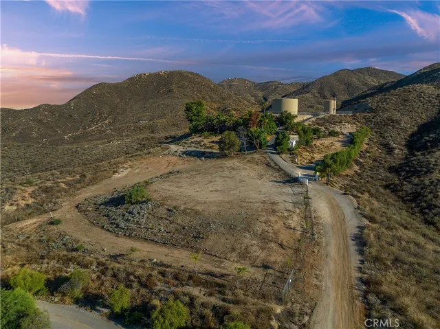 a view of a dry yard with mountains in the background