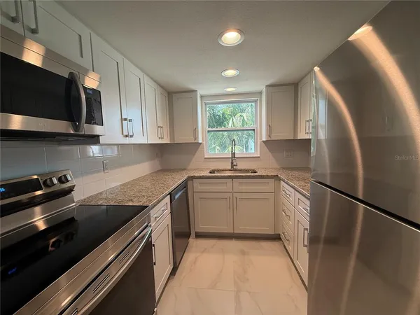 a kitchen with a sink stove and microwave