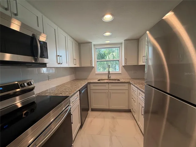a kitchen with a sink stove and microwave