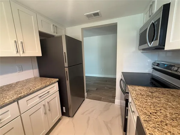 a kitchen with stainless steel appliances granite countertop a refrigerator and a stove
