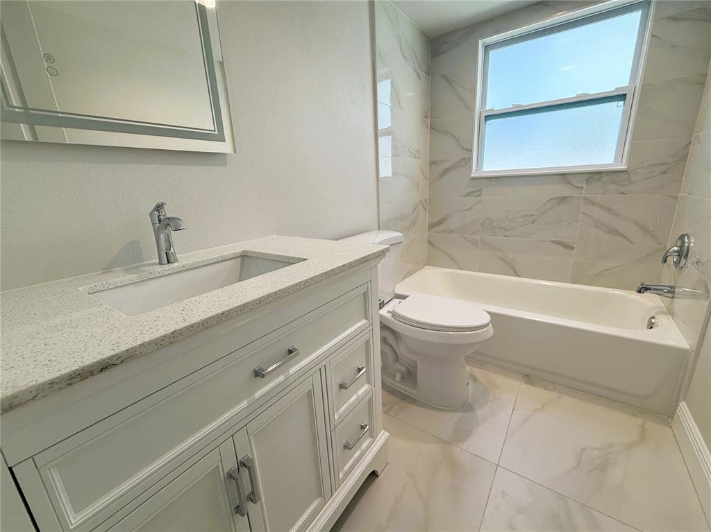 14120 Palm Street, Unit 104 Madeira Beach, FL 33708 - Photo 8 of 18 a bathroom with a sink a toilet and a bathtub
