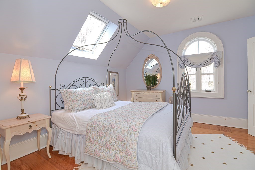 202 Paine Street Bellingham, MA 02019 - Photo 28 of 42 a bedroom with a bed a mirror on dresser and a chandelier