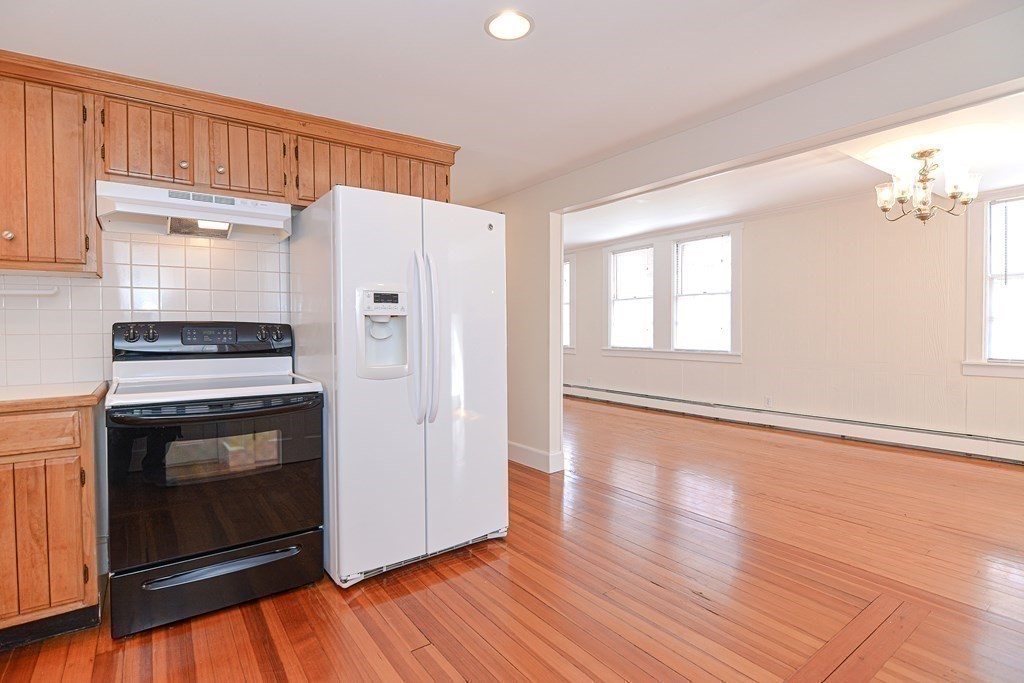 202 Paine Street Bellingham, MA 02019 - Photo 31 of 42 a kitchen with granite countertop wooden floors and white stainless steel appliances