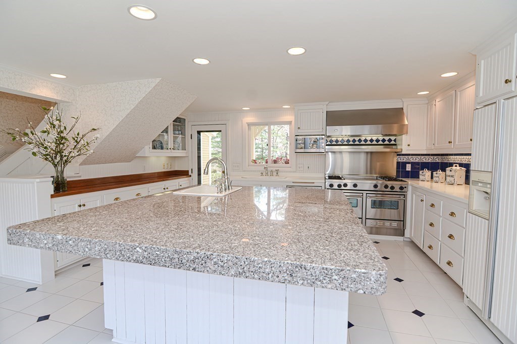202 Paine Street Bellingham, MA 02019 - Photo 4 of 42 a kitchen with stainless steel appliances granite countertop a sink stove and cabinets