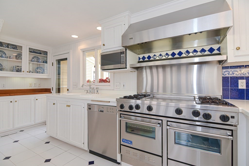 202 Paine Street Bellingham, MA 02019 - Photo 7 of 42 a kitchen with stainless steel appliances a stove a sink and a microwave