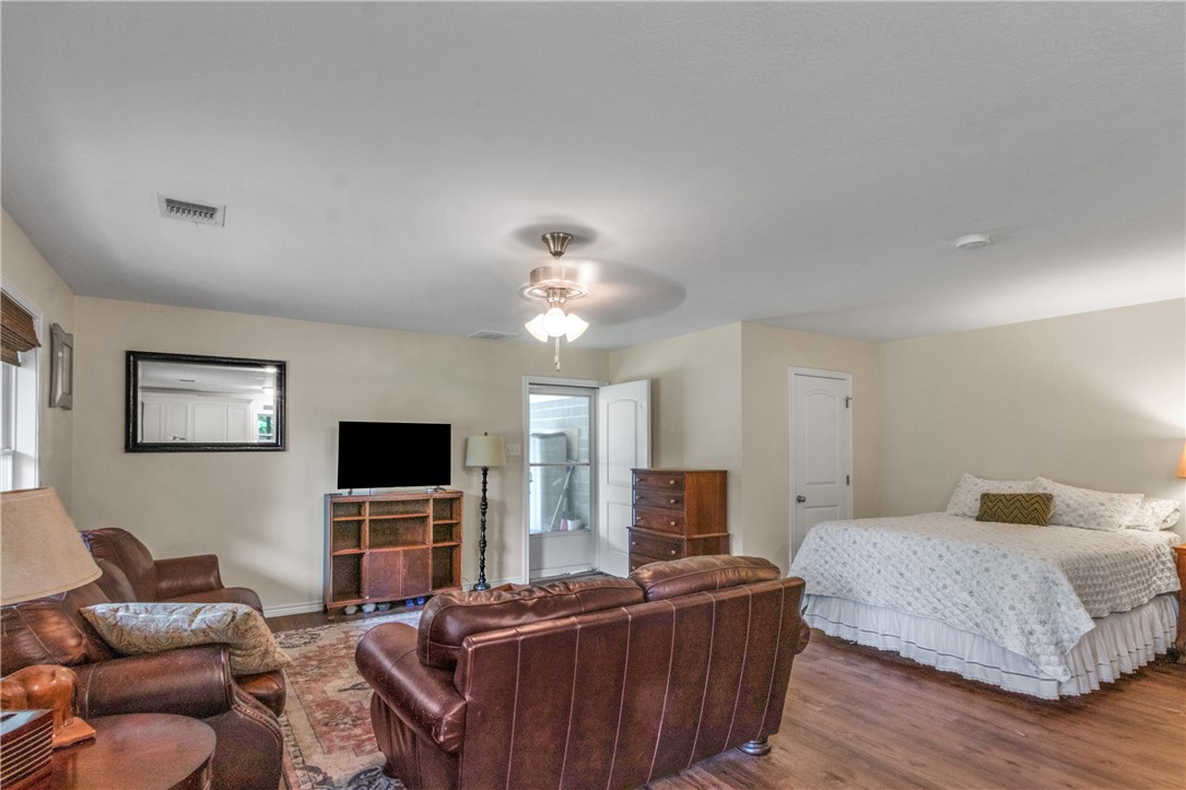 9997 Calhoun Road Bryan, TX 77808 - Photo 45 of 50 a bedroom with furniture and a flat screen tv