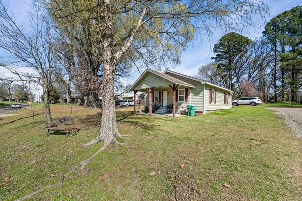 a view of a house with backyard and trees
