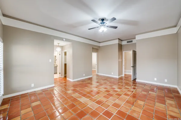 a view of a big room with wooden floor and chandelier fan