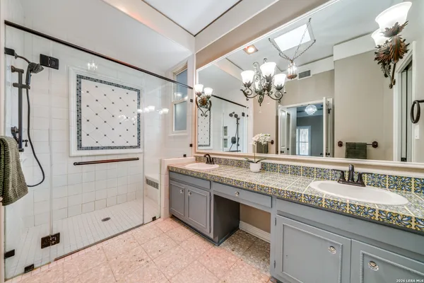 a bathroom with a granite countertop sink a large mirror and a shower