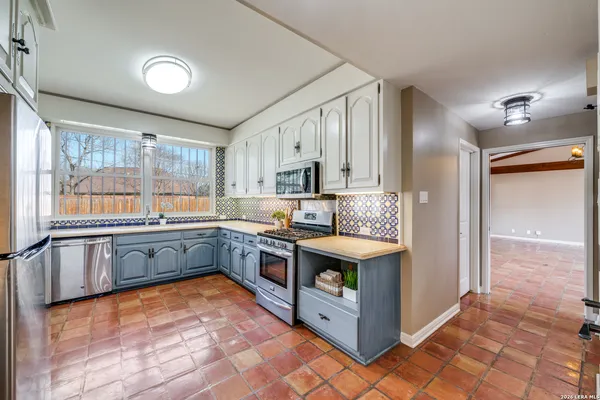a large kitchen with stainless steel appliances granite countertop a large counter top and a stove