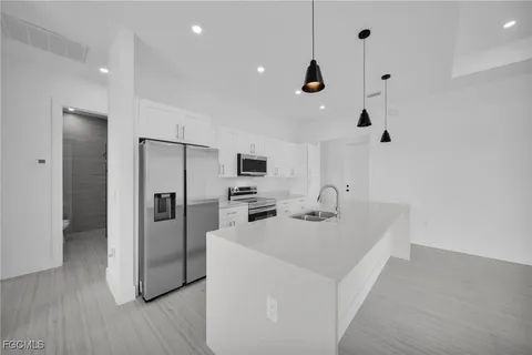 a kitchen with stainless steel appliances a refrigerator sink and microwave