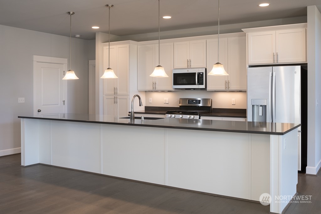 2720 Arrowroot Street Southeast Lacey, WA 98513 - Photo 3 of 18 a kitchen with stainless steel appliances a refrigerator a sink and white cabinets