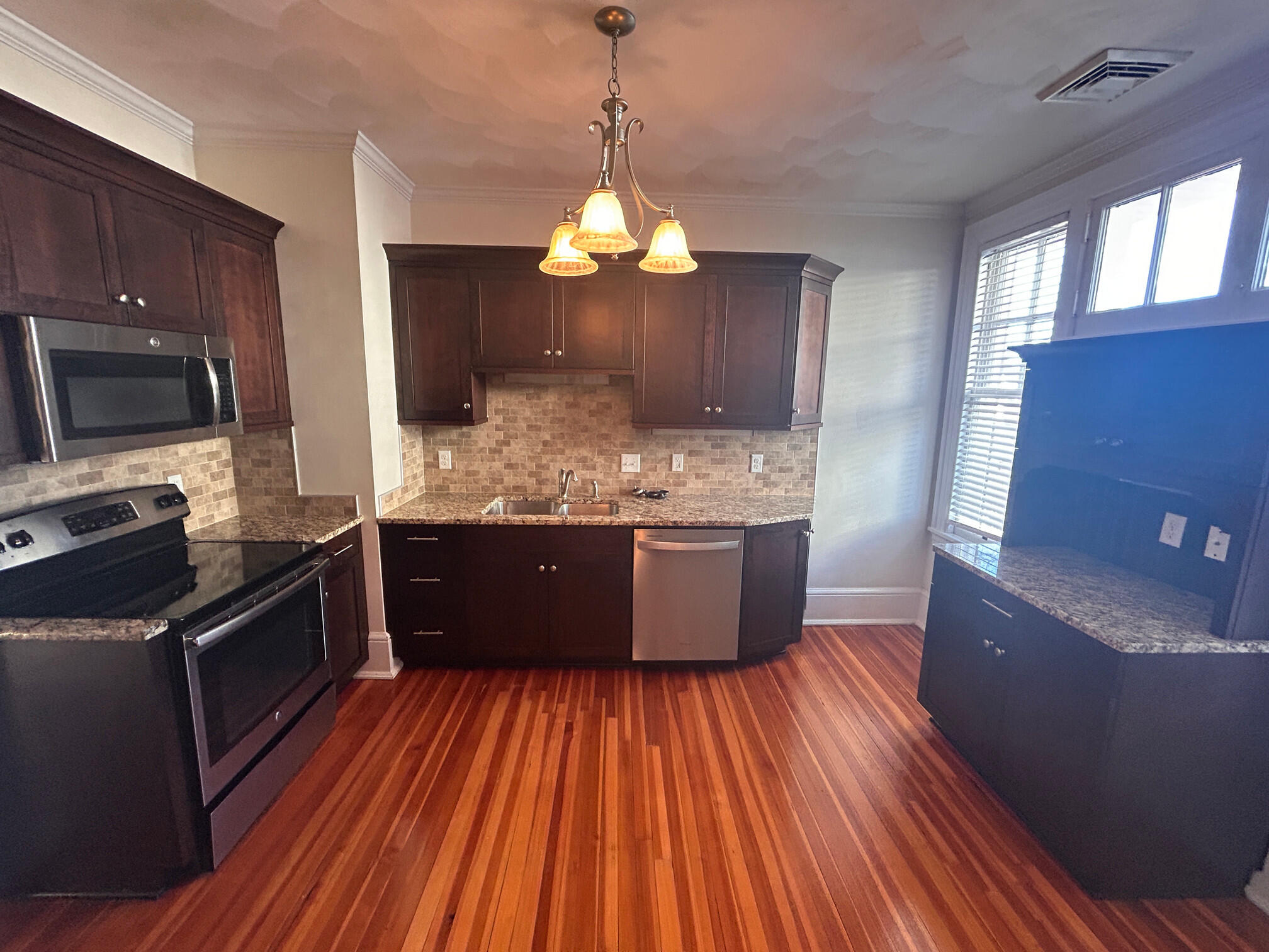 360 Walnut Avenue Southwest, Unit B Roanoke, VA 24016 - Photo 25 of 60 a kitchen with stainless steel appliances kitchen island granite countertop wooden floors and granite counter tops