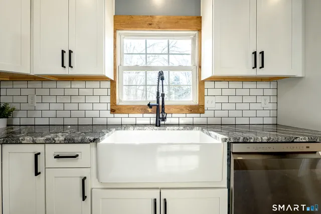 a kitchen with granite countertop a sink and a window