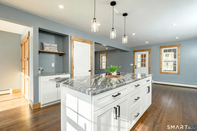 a view of a kitchen island a chandelier and wooden floor