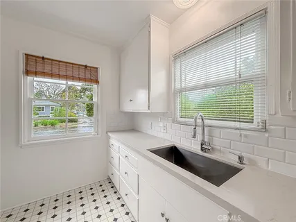 a kitchen with a sink a window and cabinets
