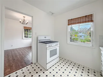 a kitchen with a stove a sink and a window