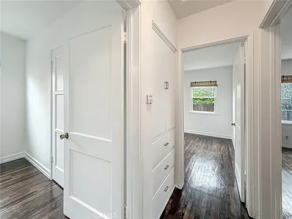 a view of a hallway with wooden floor and closet area