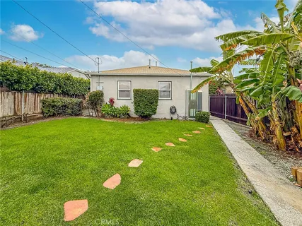 a front view of a house with a yard and potted plants