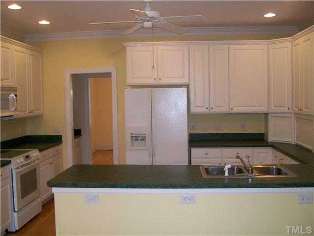 3520 Barron Berkeley Way Raleigh, NC 27612 - Photo 6 of 16 a kitchen with granite countertop a sink a stove and cabinets
