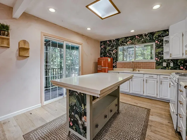 a kitchen with stainless steel appliances granite countertop a stove a sink dishwasher and a refrigerator with wooden floor