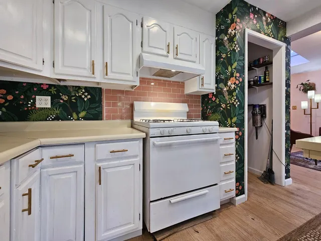 a kitchen with granite countertop white cabinets and white appliances