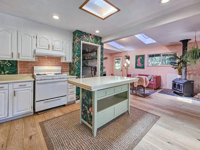 a kitchen with kitchen island a stove a sink and a refrigerator