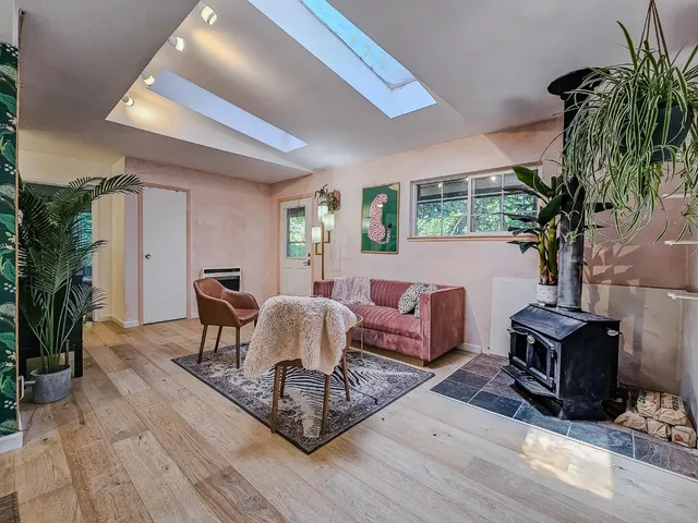 a living room with furniture a fireplace a potted plant and a large window