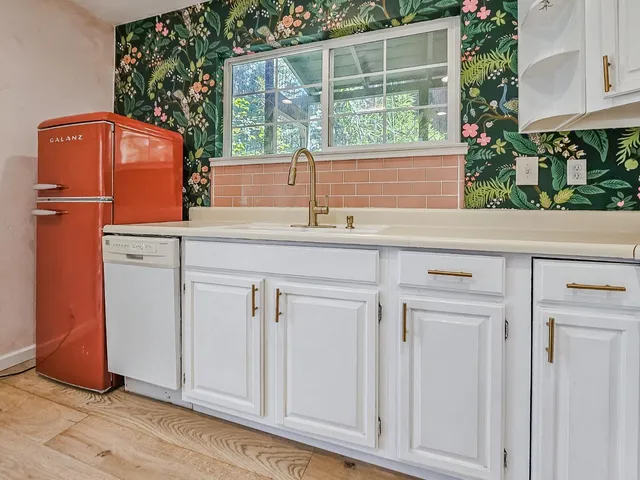 a kitchen with white cabinets and appliances