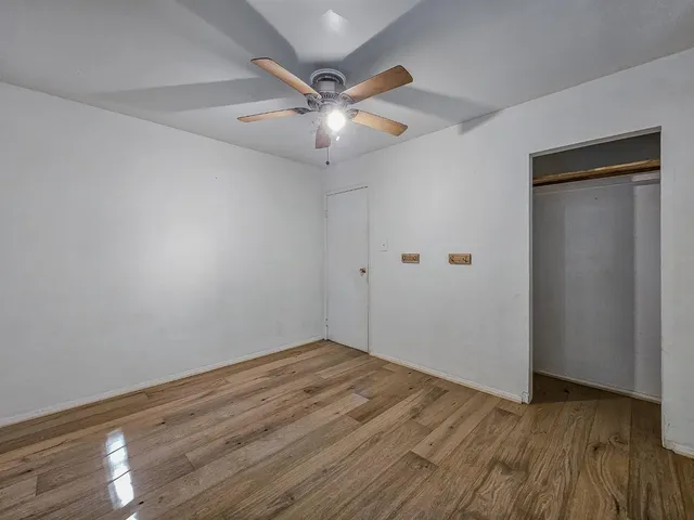 a bedroom with a bed a table chair and a window