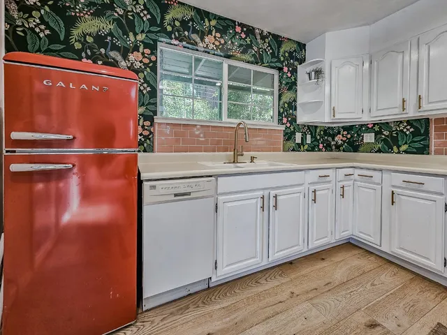 a kitchen with white cabinets and a refrigerator