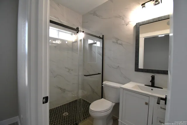 a bathroom with a sink toilet and shower