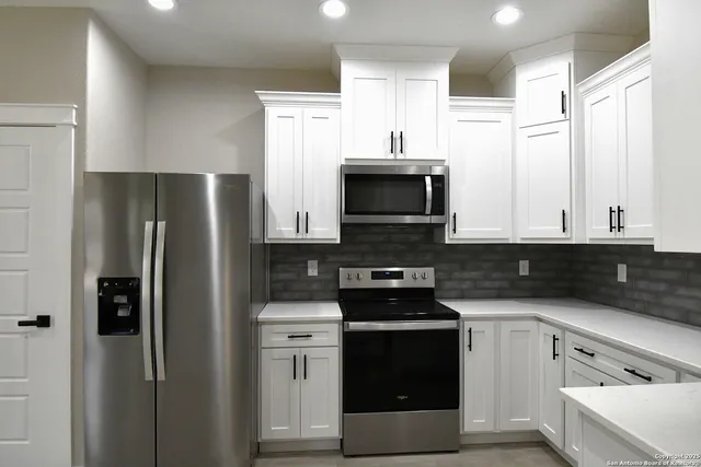 a kitchen with cabinets stainless steel appliances and a sink