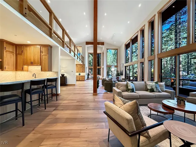 a living room with furniture wooden floor and a large window