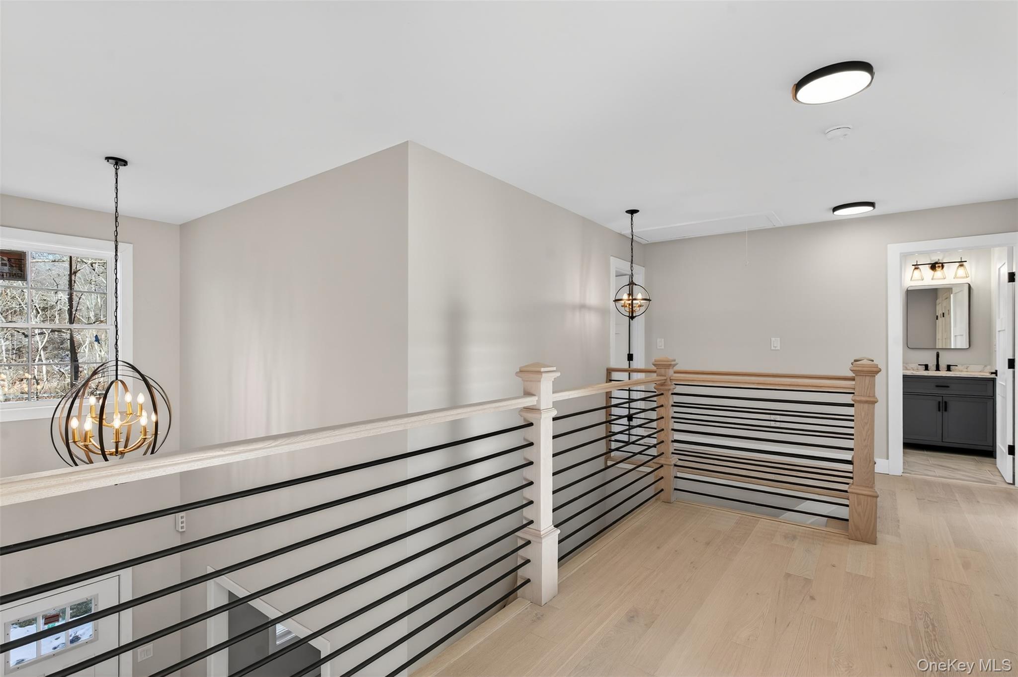 14 Harness Road Goshen, NY 10924 - Photo 26 of 40 Corridor with a chandelier, light wood finished floors, an upstairs landing, and attic access