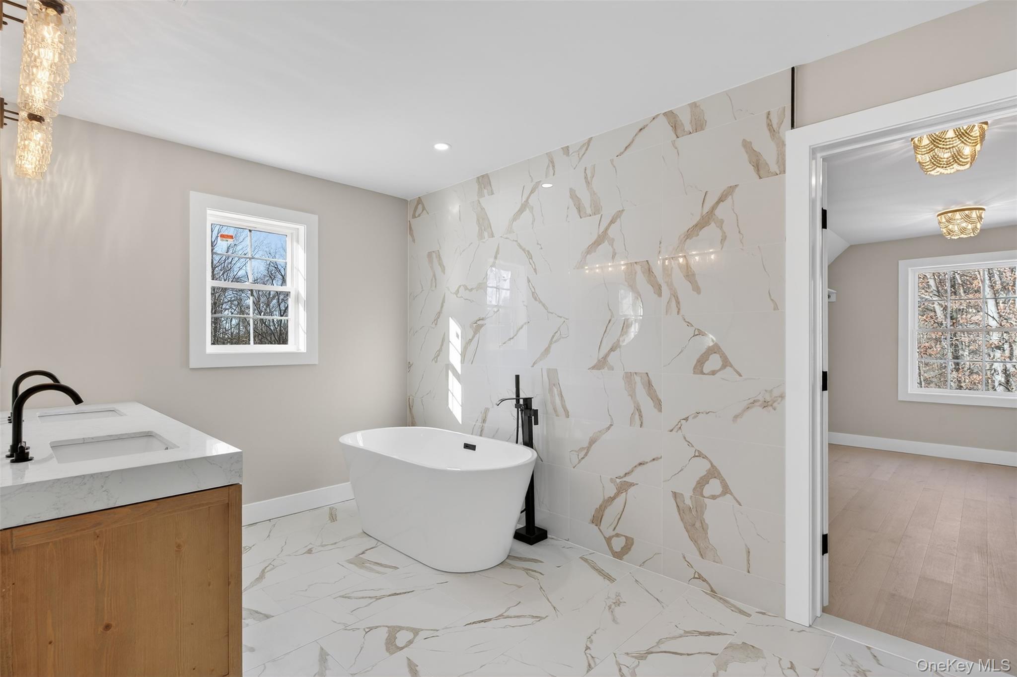 14 Harness Road Goshen, NY 10924 - Photo 32 of 40 Bathroom featuring double vanity, a soaking tub, stone wall, light marble finish floors, and recessed lighting