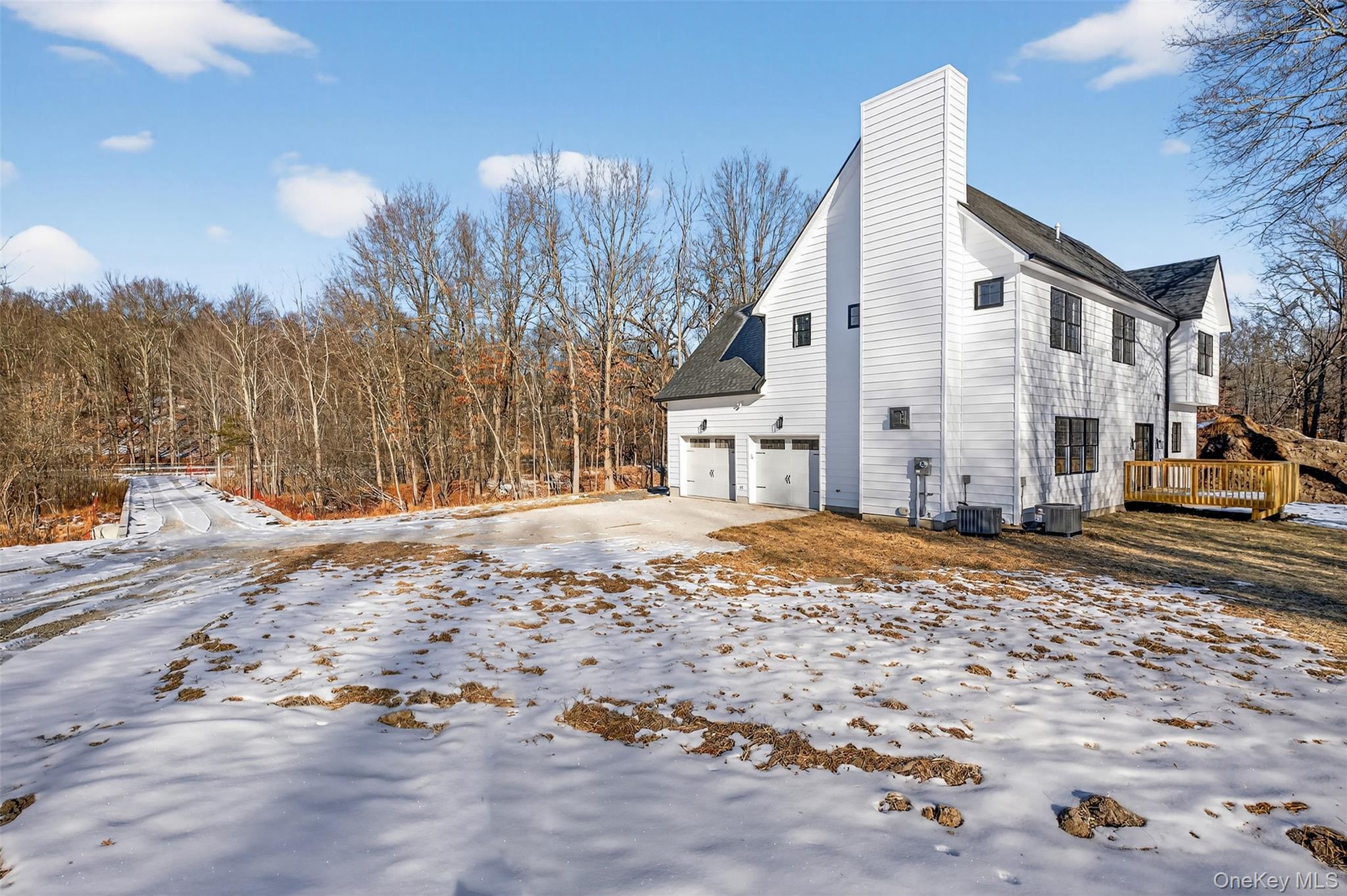 14 Harness Road Goshen, NY 10924 - Photo 5 of 40 View of snowy exterior featuring a chimney, an attached garage, roof with shingles, and a wooden deck