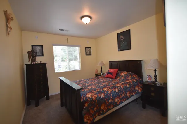 a bedroom with a bed and painting on the wall