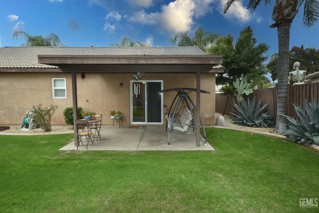 a backyard of a house with table and chairs