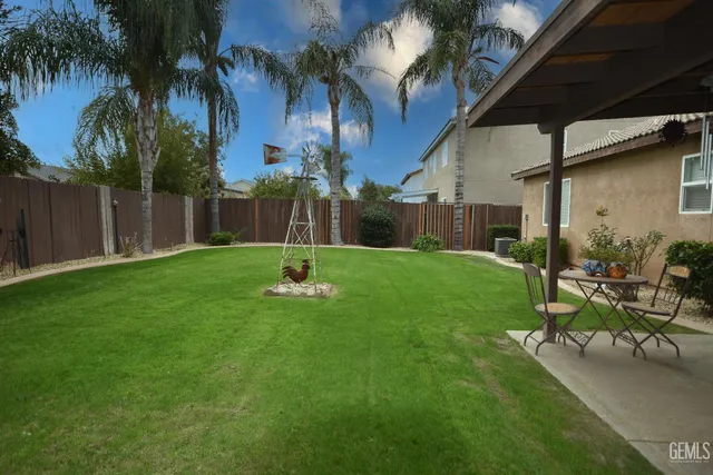 a view of a backyard with a slide trees and wooden fence