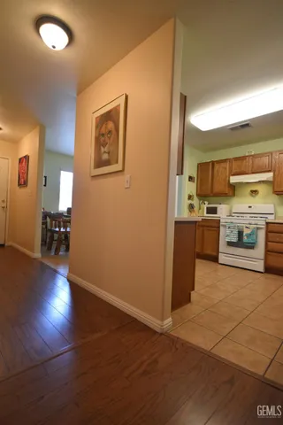 a view of a kitchen with a sink stove cabinets and empty room