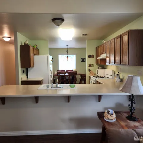 a kitchen with kitchen island granite countertop a sink a stove and a refrigerator