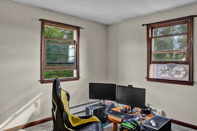 a view of a workspace with furniture and a window