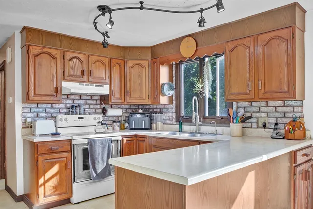 a kitchen with stainless steel appliances granite countertop a sink a stove and cabinets