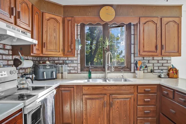 a kitchen with stainless steel appliances granite countertop a sink a stove and cabinets