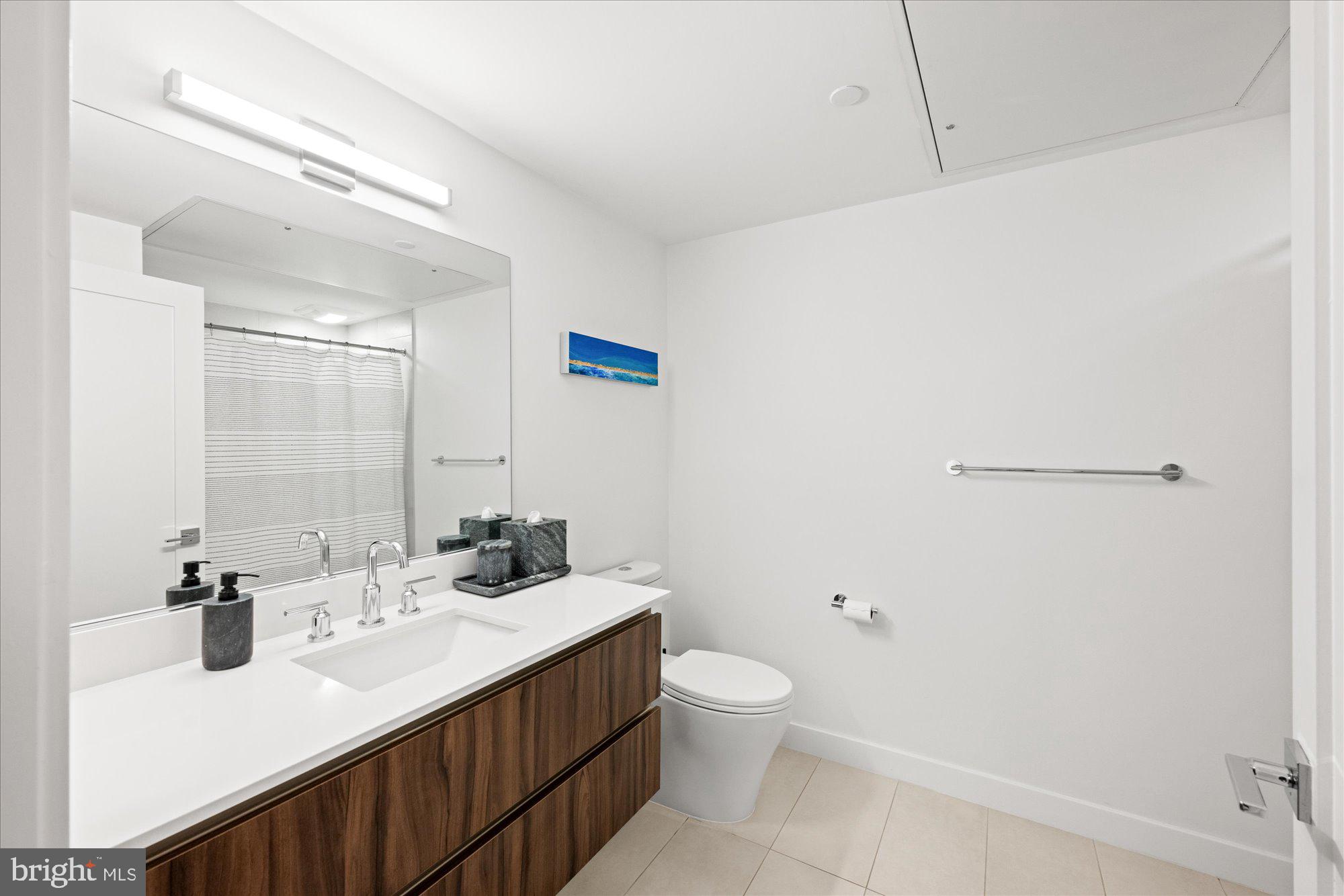 37 L Street Southeast, Unit 1105 Washington, DC 20003 - Photo 8 of 16 a bathroom with a sink a toilet and a mirror