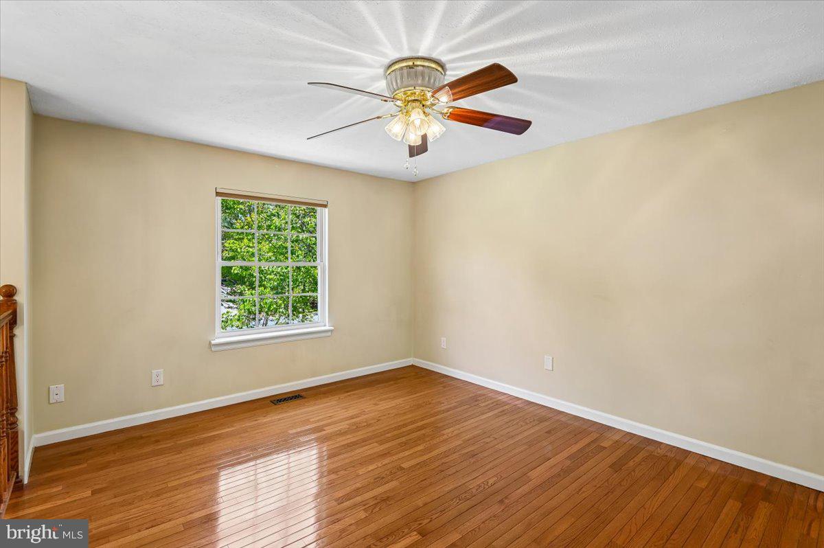 1928 Canonchet Court Hanover, MD 21076 - Photo 16 of 32 wooden floor in an empty room with a window