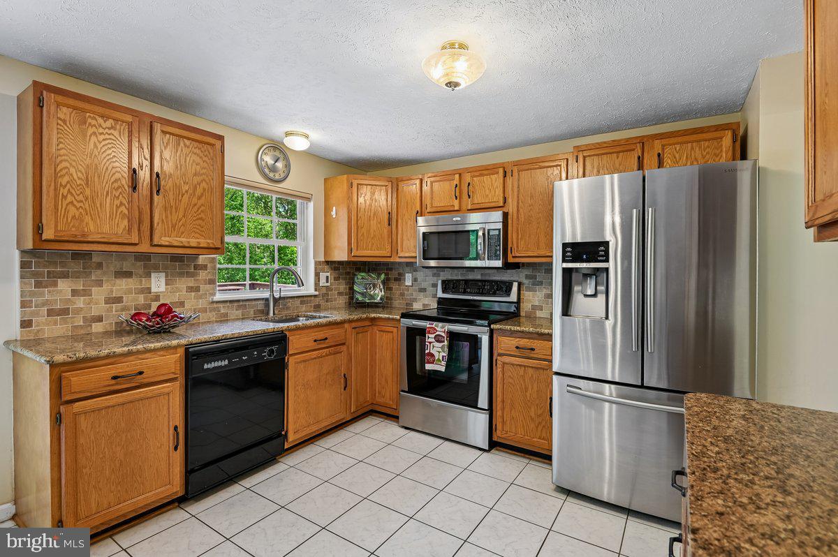 1928 Canonchet Court Hanover, MD 21076 - Photo 6 of 32 a kitchen with stainless steel appliances granite countertop a refrigerator sink and stove