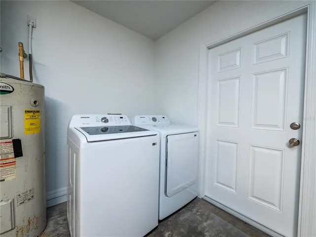 a spacious bedroom with a bed a couch and a chandelier